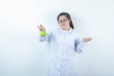 Elinde yeşil elma tutan doktor üniformalı genç bir kız. Yüksek kalite fotoğraf