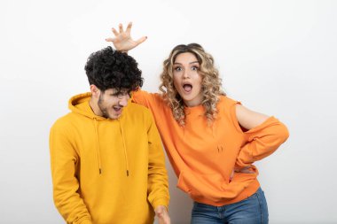 Beyaz duvarın üzerinde dikkatsizce oynayan genç ve çekici bir çiftin portresi. Yüksek kalite fotoğraf