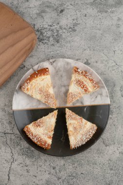 Tahtanın etrafına hindistan cevizi parçacıkları serpiştirilmiş lezzetli kek dilimleri. Yüksek kalite fotoğraf