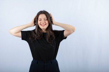 Siyah elbiseli, başını kapalı gözlerle tutan genç bir kadının portresi. Yüksek kalite fotoğraf