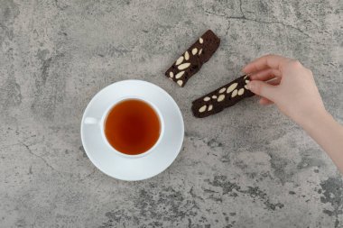 Female hand holding crispy biscuits on stone table. High quality photo