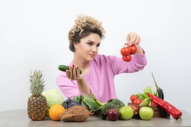 Masada elinde taze domates ve salatalık tutan güzel bir kadın. Yüksek kalite fotoğraf