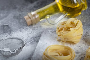 Tahta ahşap tagliatelle tahtasının üzerinde un ve zeytinyağı olan yuvaları var. Yüksek kalite fotoğraf