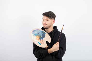 Elinde fırça ve palet tutan genç ve yakışıklı bir sanatçı. Yüksek kalite fotoğraf