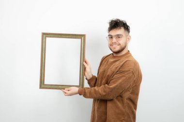 Gözlüklü genç adamın boş bir çerçeve tutarken fotoğrafı. Yüksek kalite fotoğraf