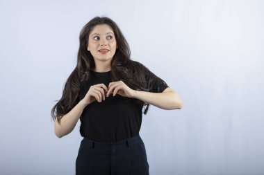 Siyah elbiseli güzel bir kız beyaz arka planda kameraya poz veriyor. Yüksek kalite fotoğraf