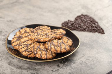Siyah yulaflı bisküvi tabağı ve çikolatayı taş masaya bırak. Yüksek kalite fotoğraf