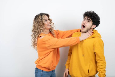 Genç kıvırcık saçlı kadın esmer adamı boğuyor. Yüksek kalite fotoğraf