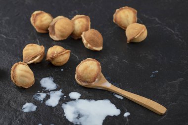 Tahta kaşık cevizli kurabiye ve üzerine siyah süt dökülmüş. Yüksek kalite fotoğraf