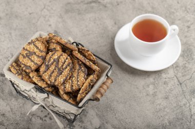 Bir sepet yulaflı kurabiye ve mermer üzerine siyah çay. Yüksek kalite fotoğraf