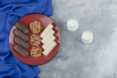 Yulaf ezmeli kırmızı tabak ve bir bardak sütlü çikolata çubuğu. Yüksek kalite fotoğraf