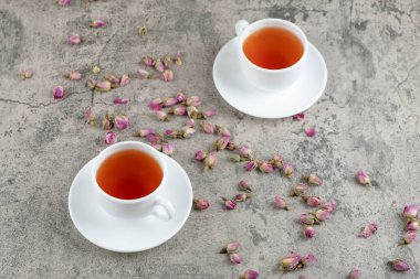 Mermer zemin üzerinde kurumuş çiçekler olan iki fincan siyah çay. Yüksek kalite fotoğraf