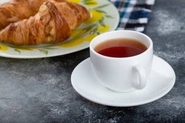 Tereyağlı kruvasan ve bir fincan çay. Yüksek kalite fotoğraf