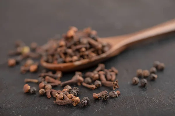 Stapel Gedroogde Natuurlijke Kruidnagel Met Houten Lepel Zwart Oppervlak Hoge — Stockfoto