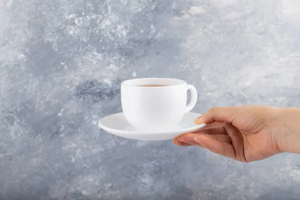 Női Kéz Kezében Egy Fehér Csésze Fekete Tea Egy Háttér — Stock Fotó