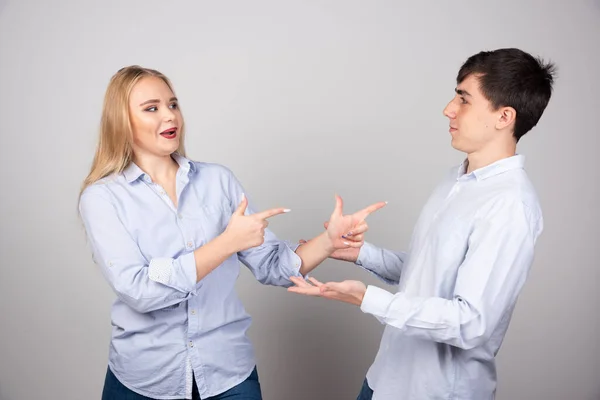 Portrait Young Couple Pointing Fingers While Standing Gray Wall High — Stock Photo, Image