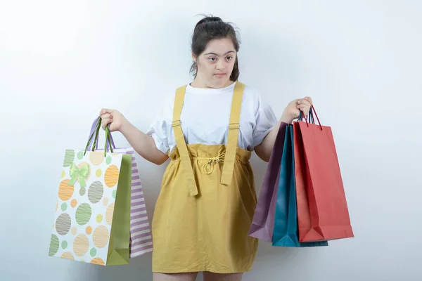 Adorable Joven Con Síndrome Sosteniendo Bolsas Compras Sobre Fondo Blanco —  Fotos de Stock