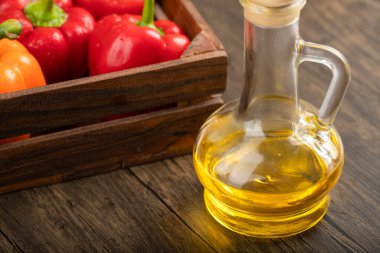 Tahta arka planda taze dolmalık biber ve zeytinyağı kutusu. Yüksek kalite fotoğraf