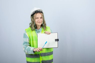 Genç bayan mühendisin beyaz duvarın üzerinde projesini gösteren fotoğrafı. Yüksek kalite fotoğraf