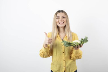 Karnabahar taşıyan güzel, gülümseyen bir kadın manken resmi. Yüksek kalite fotoğraf