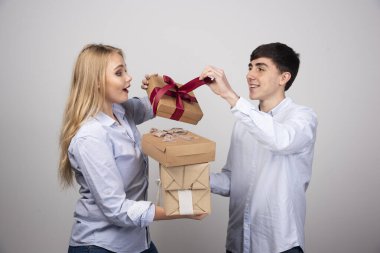 Adam gri duvara karşı sevgilisine Noel hediyeleri veriyor. Yüksek kalite fotoğraf