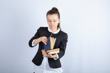 Beyaz arka plan üzerine ilginç kitaplar okuyan genç bir kızın portresi. Yüksek kalite fotoğraf