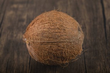 Tahta arka planda tek bir olgun, kıllı hindistan cevizi var. Yüksek kalite fotoğraf