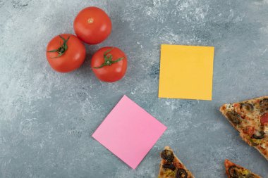 Yapıştırmalı taze kırmızı domatesler ve arka planda pizza dilimleri. Yüksek kalite fotoğraf