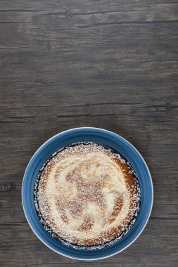 Ahşap masaya konmuş şekerli mavi bir tabak lezzetli turta. Yüksek kalite fotoğraf