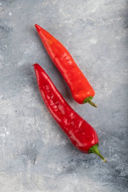 Mermer zemin üzerine iki kırmızı biber yerleştirilmiş. Yüksek kalite fotoğraf