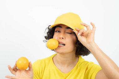 Portakallı güzel bir kadının portresi beyaz arka planda poz veriyor.  