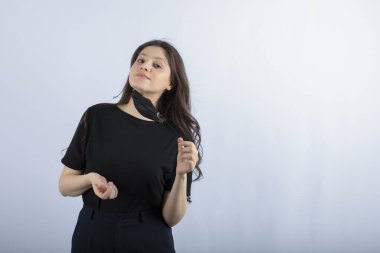 Beyaz duvarın üzerinde siyah tıbbi maske takan güzel esmer kız. Yüksek kalite fotoğraf