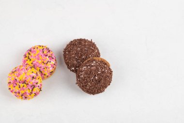 Beyaz arka planda serpiştirilmiş kremalı kurabiyelerin çeşitliliği. Yüksek kalite fotoğraf