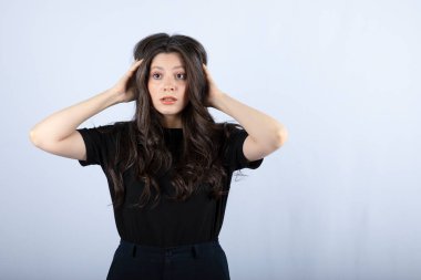 Beyaz arka plandaki bir şeye şaşıran uzun saçlı bir kızın görüntüsü. Yüksek kalite fotoğraf