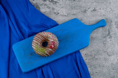 Mavi kesme tahtasına iki lezzetli çikolata parçacıklı çörek. Yüksek kalite fotoğraf