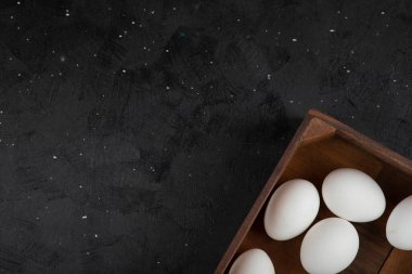 Siyah arka planda organik çiğ yumurta dolu tahta kutu. Yüksek kalite fotoğraf