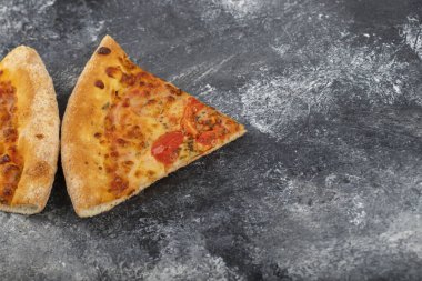 Taş zemine yerleştirilmiş iki dilim lezzetli peynirli pizza. Yüksek kalite fotoğraf