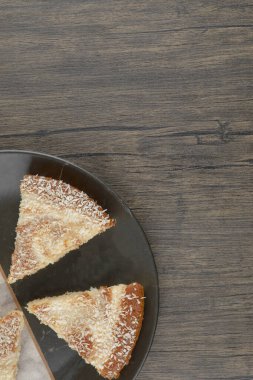 Tahta masaya hindistan cevizi parçacıkları serpiştirilmiş lezzetli kek dilimleri. Yüksek kalite fotoğraf