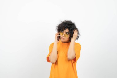 Akıllı telefonlu genç kadın beyaz arka planda poz veriyor 