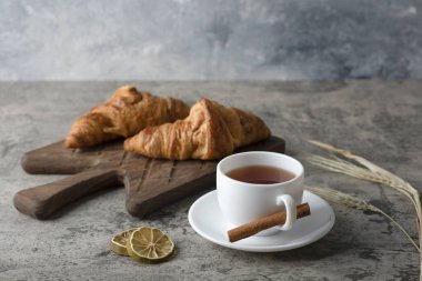 Taze ve lezzetli kruvasanlar ve bir fincan sıcak çay. Yüksek kalite fotoğraf