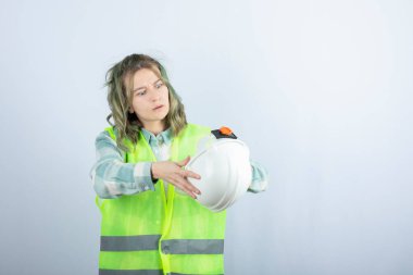 Beyaz arka planda yeşil yelek giyen genç işçinin fotoğrafı. Yüksek kalite fotoğraf