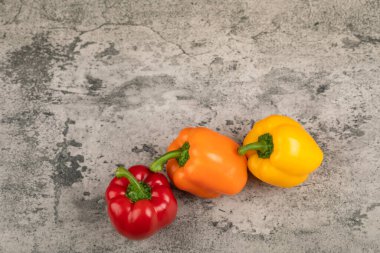 Taş yüzeyine yerleştirilmiş tatlı renkli dolmalık biberler. Yüksek kalite fotoğraf