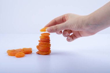 Beyaz arka planda kurumuş kayısı yiyen bir kadın. Yüksek kalite fotoğraf