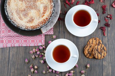 Tahta masaya siyah çay konmuş lezzetli bir turta tabağı. Yüksek kalite fotoğraf