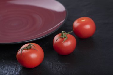 Siyah masaya yerleştirilmiş taze kırmızı domatesler. Yüksek kalite fotoğraf