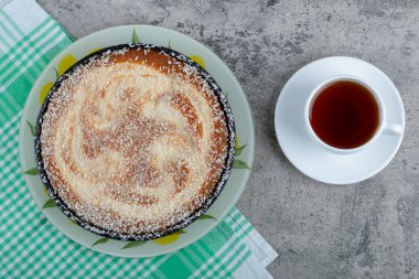 Taş bir masanın üzerine bir fincan siyah çay ile bir tabak lezzetli turta. Yüksek kalite fotoğraf