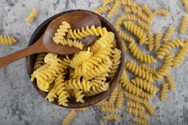 Taş yüzeyinde ahşap fusilli makarna kasesi. Yüksek kalite fotoğraf