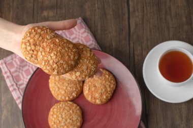 Tahta masada yulaf ezmeli bisküvi tutan kadın eli. Yüksek kalite fotoğraf