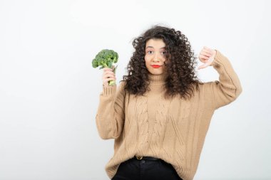 Sağlıklı brokoli ile örülü süveter giyen güzel bir kadın baş parmağını kaldırıyor. Yüksek kalite fotoğraf