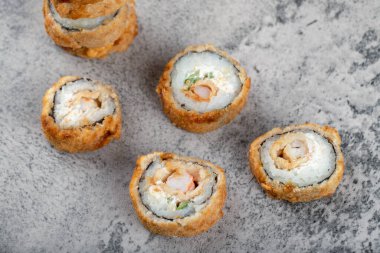 Kayadan bir arka planda sıcak kızarmış suşi ruloları. Yüksek kalite fotoğraf